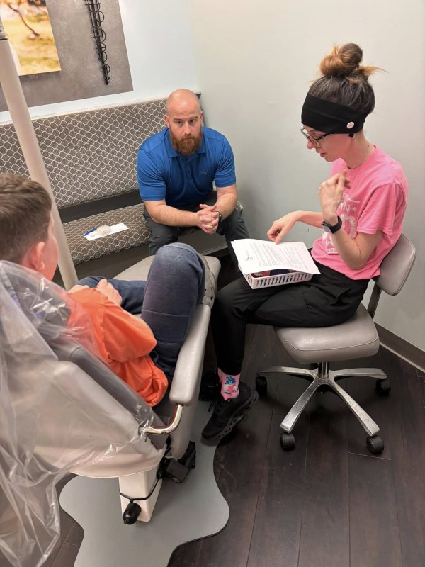 Boy and dad receiving consultation from dentist 