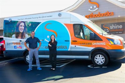 Two people standing next to company van 