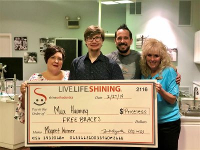 Group of people smiling and holding a check 