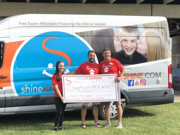 People smiling and holding a big check