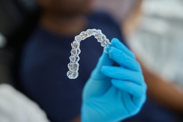 gloved hand holding retainer